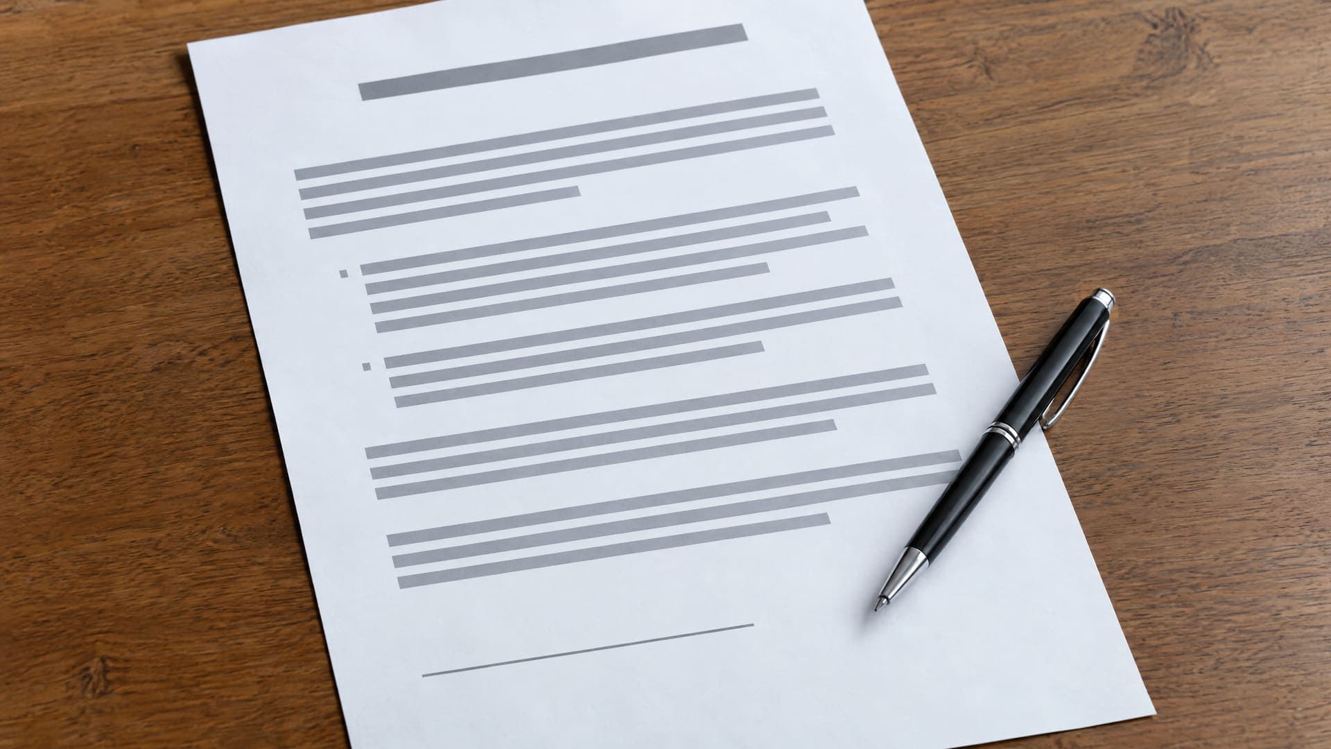 Vertrag mit Stift und Unterlagen auf einem Schreibtisch, Text unleserlich