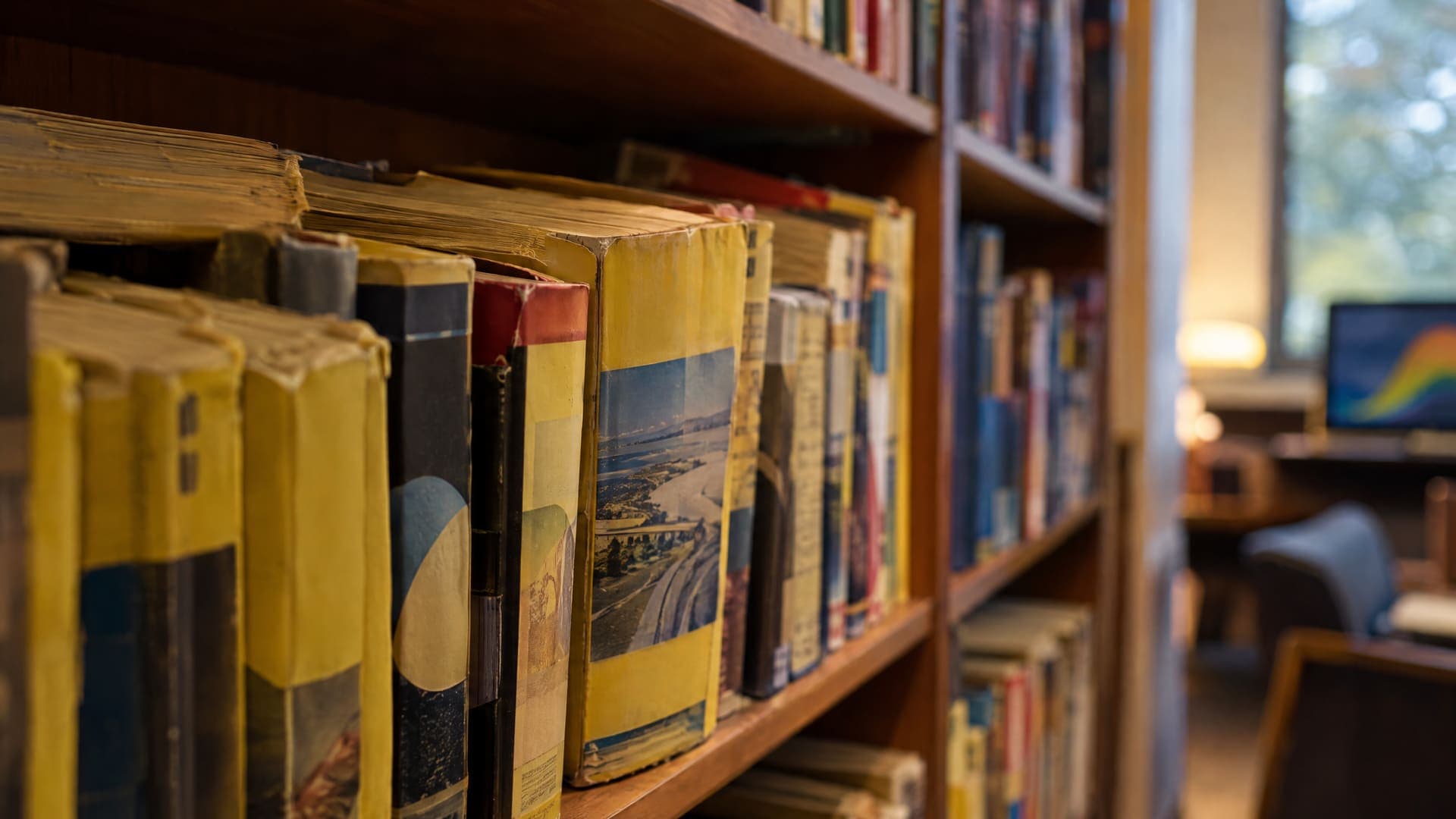 Alte gedruckte Telefonbücher und Branchenbücher stehen in einem Regal, Rückenbeschriftungen unleserlich