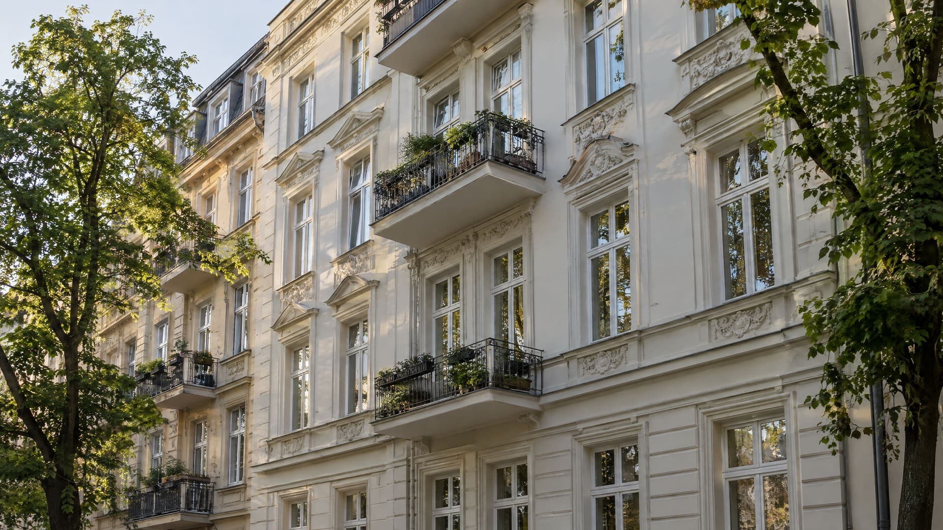 Fassade eines sanierten Berliner Altbaus mit hohen Fenstern und Stuckdetails im weichen Morgenlicht, ohne Personen, Schilder nicht lesbar