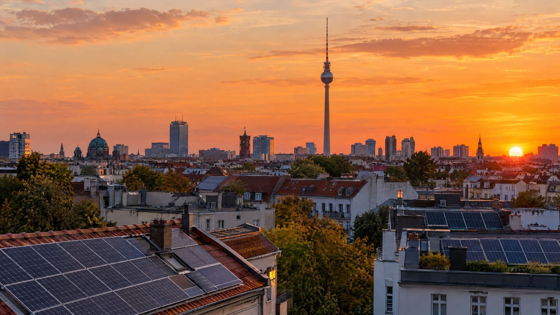 Berliner Dachlandschaft mit Photovoltaik und Fernsehturm bei Sonnenuntergang